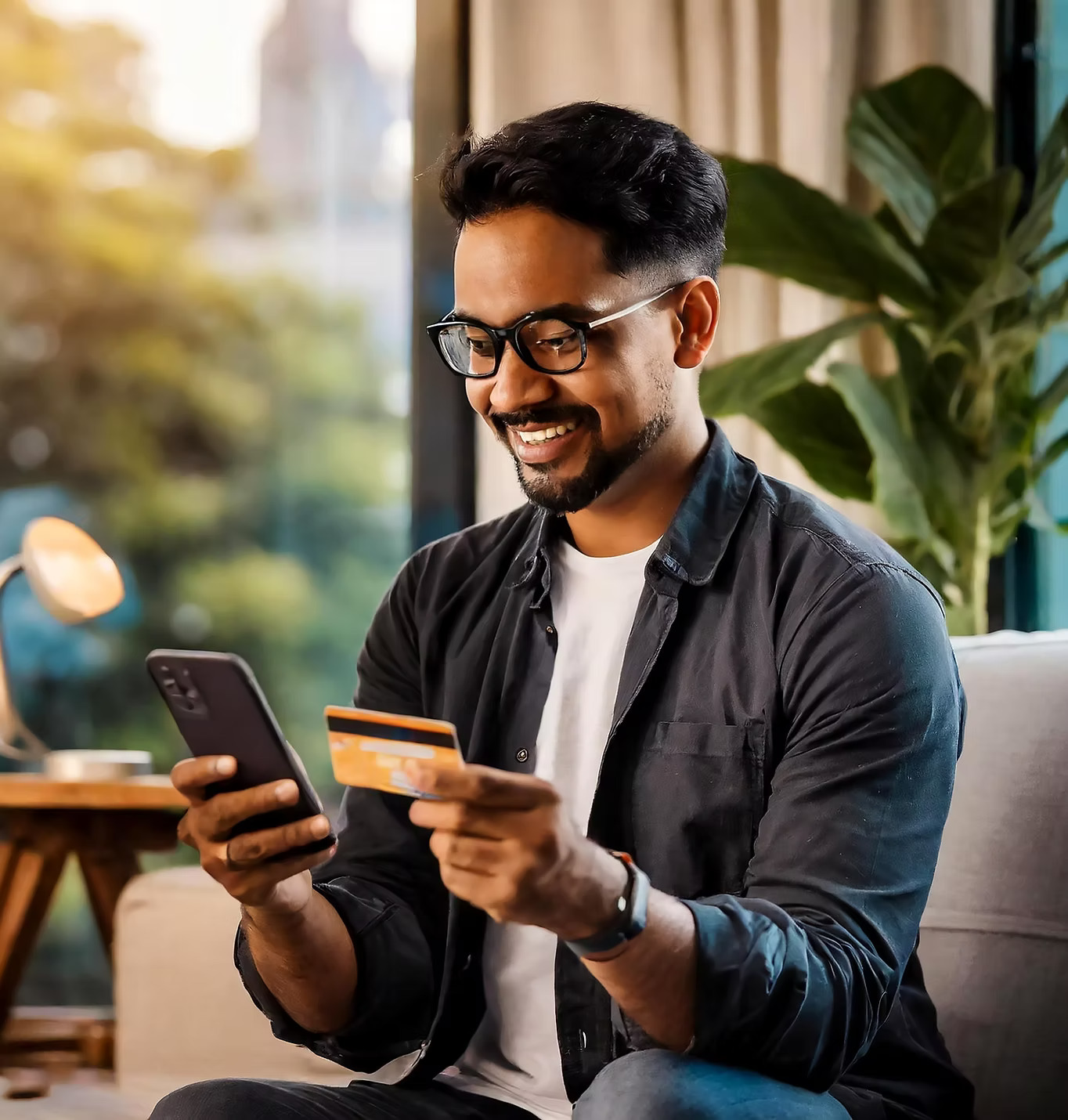 Happy man using card and phone